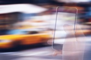 Smartphone Against Blurred Yellow Taxis